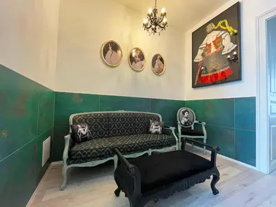 a living room with a bench and portraits on the wall at Vintage & Modern - best of both worlds in the heart of Prague in Prague