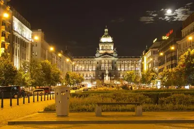 a large building with a bench in front of it at night at Vintage & Modern - best of both worlds in the heart of Prague in Prague