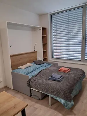 a bedroom with two beds and a large window at Modern flat with Rooftop Terrace in Prague