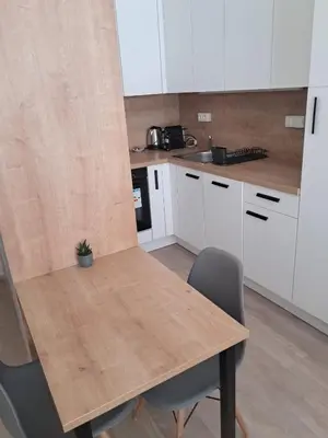 a kitchen with a wooden table and chairs at Modern flat with Rooftop Terrace in Prague