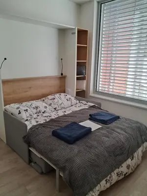 a bedroom with a bed with two blue pillows on it at Modern flat with Rooftop Terrace in Prague
