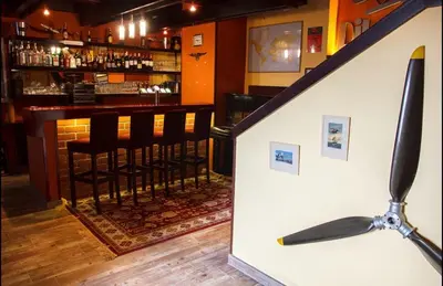 a bar with black bar stools in a restaurant at Restaurace-Penzion U Pilota in Kněževes