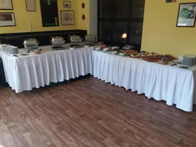 a row of white tables with food on them at Restaurace-Penzion U Pilota in Kněževes