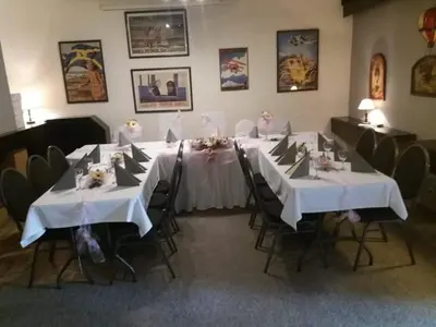 a dining room with two tables with white tablecloths at Restaurace-Penzion U Pilota in Kněževes