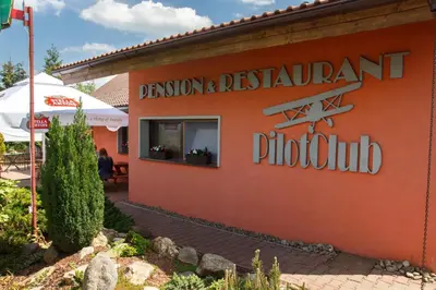 a sign on the side of a restaurant building at Restaurace-Penzion U Pilota in Kněževes