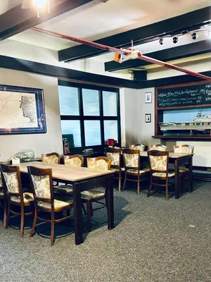 a dining room with tables and chairs and a chalkboard at Restaurace-Penzion U Pilota in Kněževes