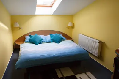 a bedroom with a large bed with blue pillows at Restaurace-Penzion U Pilota in Kněževes