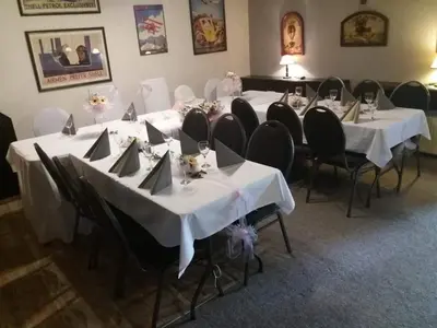 a group of tables with white table cloths and chairs at Restaurace-Penzion U Pilota in Kněževes