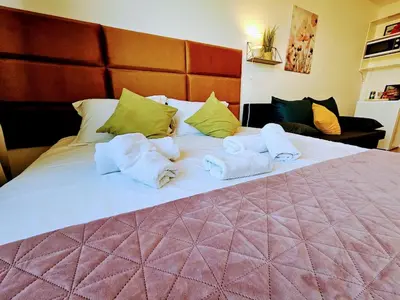a bed with towels and pillows on it at TERRACE-VIEW PRAGUE STUDIOS for Business & Leisure, FREE PARKING, Near Metro, Gym in Prague