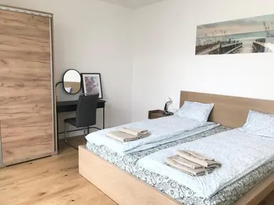 a bedroom with two beds and a desk with a mirror at Apartmantplus01 in Prague
