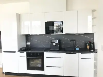 a kitchen with white cabinets and a black stove at Apartmantplus01 in Prague