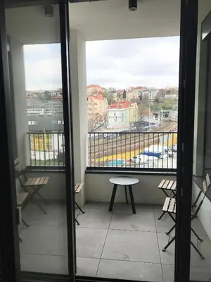 a room with a balcony with chairs and a table at Apartmantplus01 in Prague