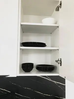 a cupboard with black plates and bowls in it at Apartmantplus01 in Prague