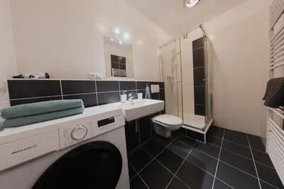a bathroom with a washing machine and a sink at Apartment Mostecka in Prague