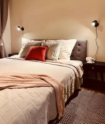 a bedroom with a bed with a red pillow on it at Quiet and Cozy Apartment by the Walls of Vyšehrad in Prague