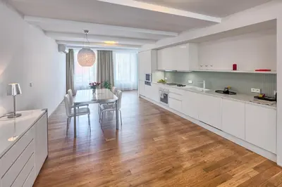 a kitchen with white cabinets and a table with chairs at Central Prague Residence Karlín in Prague