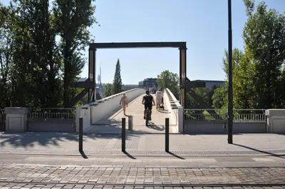 a bridge with two people riding a bike on it at Central Prague Residence Karlín in Prague