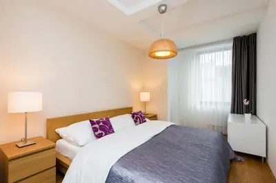 a bedroom with a large bed with purple pillows at Central Prague Residence Karlín in Prague