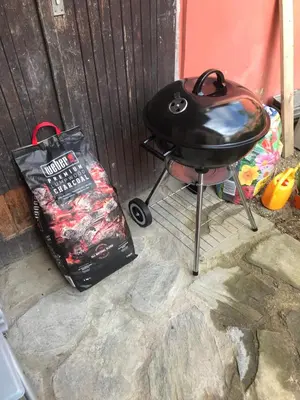 a bbq grill and a bag next to a fence at Country home Chez Nous U nas in Tetín