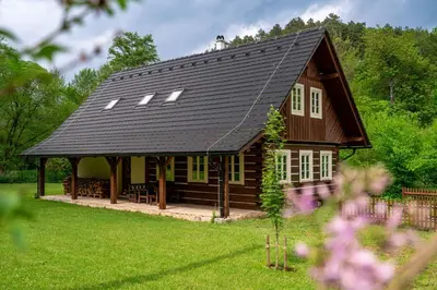 a large wooden house with a gambrel roof at Roubenka pod hradem Kokořín in Kaninský Dŭl
