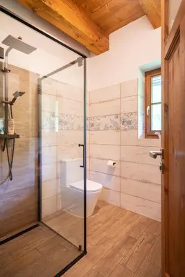 a bathroom with a glass shower with a toilet at Roubenka pod hradem Kokořín in Kaninský Dŭl