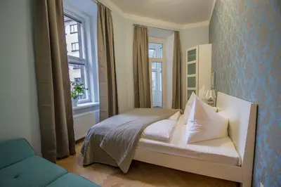 a bedroom with a white bed and two windows at Royal Apartment with Sauna and Billiards in Prague