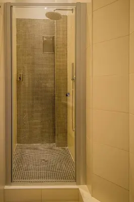 a shower with a glass door in a bathroom at Royal Apartment with Sauna and Billiards in Prague