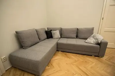 a grey couch in a room with a wooden floor at Royal Apartment with Sauna and Billiards in Prague