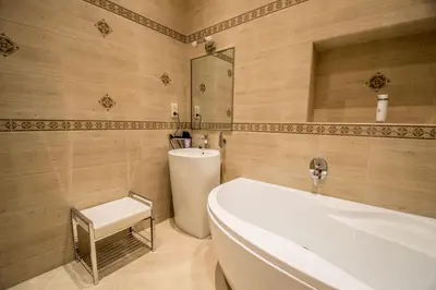 a bathroom with a tub and a toilet and a sink at Royal Apartment with Sauna and Billiards in Prague