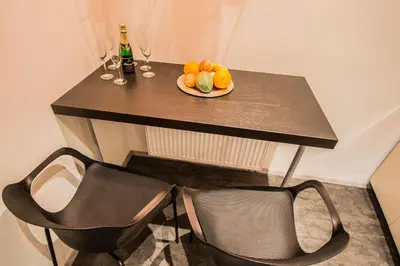 a table with a plate of fruit and wine glasses at Royal Apartment with Sauna and Billiards in Prague