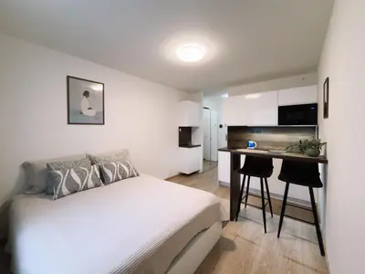 a bedroom with a bed and a small kitchen at Studio apartments Kubanske in Prague