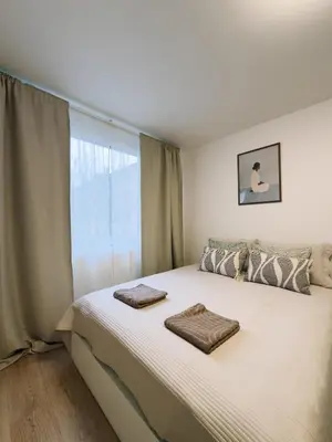 a bedroom with a large white bed with a window at Studio apartments Kubanske in Prague