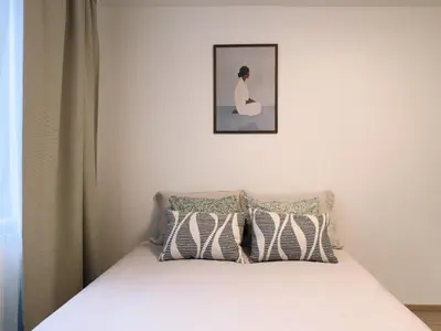 a bedroom with a bed with a picture above it at Studio apartments Kubanske in Prague