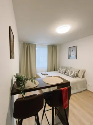 a living room with a bed and a table and chairs at Studio apartments Kubanske in Prague