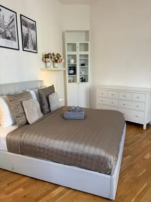 a bedroom with a large bed and a white dresser at Cozy Flat in the Heart of Prague in Prague