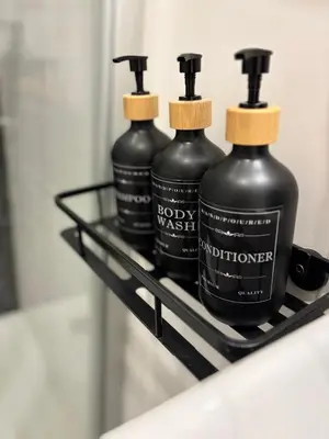 three black bottles on a shelf in a bathroom at Cozy Flat in the Heart of Prague in Prague