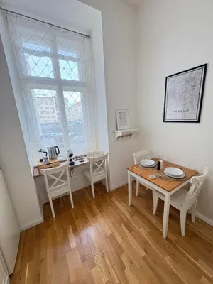 a dining room with a table and chairs and a window at Cozy Flat in the Heart of Prague in Prague