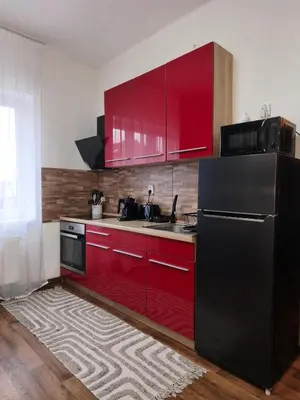 a kitchen with red cabinets and a black refrigerator at VilaVala in Nymburk