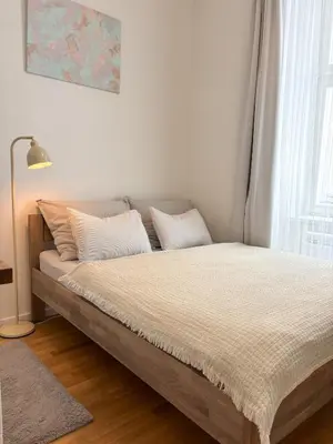 a bed with white sheets and pillows in a bedroom at Museum Park Apartment in Prague