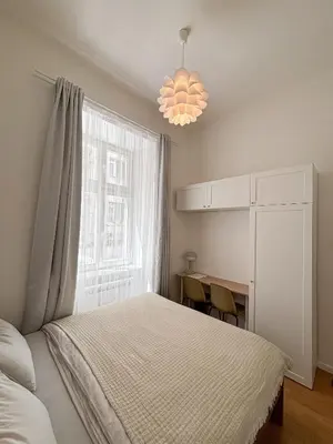 a bedroom with a bed and a window and a desk at Museum Park Apartment in Prague