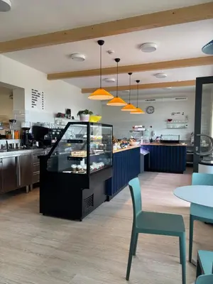 a restaurant with a counter and a table and chairs at Apartmány Hrachov in Svatý Jan
