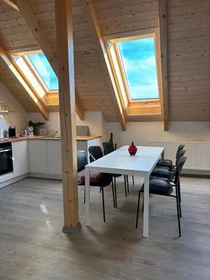 a white table and chairs in a kitchen with skylights at Apartmány Hrachov in Svatý Jan