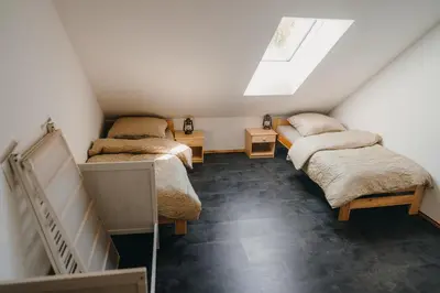 a attic room with three beds and a skylight at Zážitkový Ranč Nevada in Velká Lečice