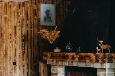 a fireplace with a wooden mantel with a deer on it at Zážitkový Ranč Nevada in Velká Lečice