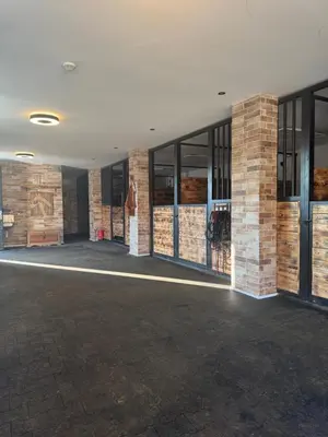 an empty building with glass doors and brick walls at Zážitkový Ranč Nevada in Velká Lečice