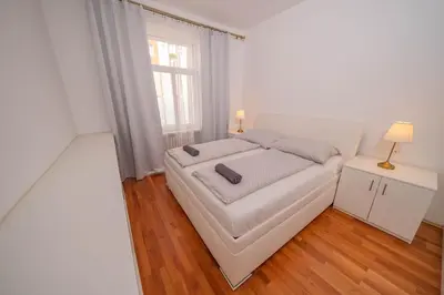 a white bedroom with a bed and a window at 4 Bob's Apartments - 3 bedrooms, King size beds in Prague