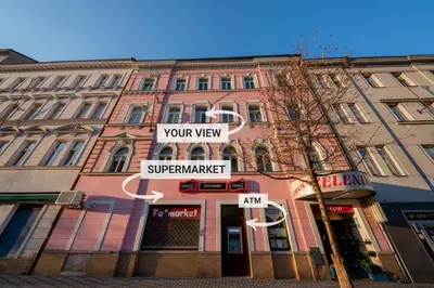 a city street with a clock in front of buildings at 4 Bob's Apartments - 3 bedrooms, King size beds in Prague