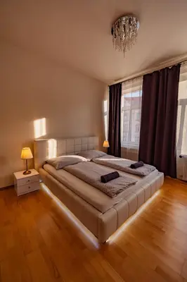 a bedroom with a large bed and a chandelier at 5 Bob's Apartment - 2 bedrooms with King Size beds in Prague