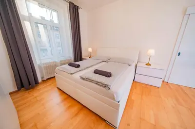 a white bed in a room with a large window at 5 Bob's Apartment - 2 bedrooms with King Size beds in Prague