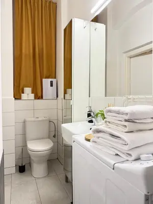 a white bathroom with a toilet and a sink at The Rest Point Prague in Prague